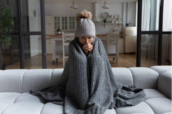 Person relaxing under a cozy throw for emotional comfort
