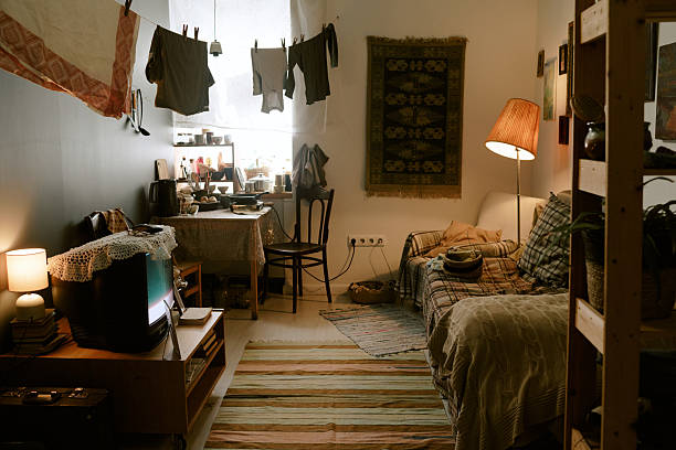 Rustic, lived-in room with a patterned blanket on the sofa and clothes drying.