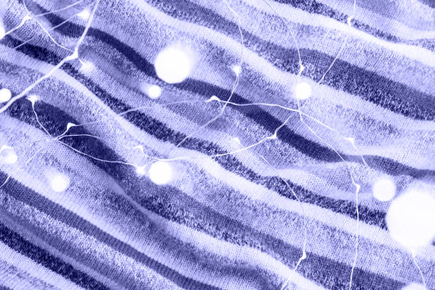 Abstract striped purple blanket fabric with glowing white light dots and lines.