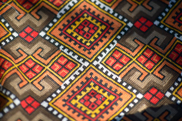 Close-up of a colorful, intricately patterned woven blanket with geometric designs.