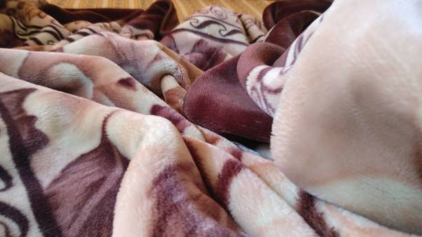 Soft, plush blanket with a warm brown and cream floral pattern, showing texture.