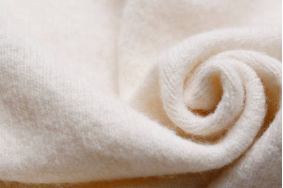 Close-up of luxurious, creamy, woven fabric, ideal for a comfortable blanket.