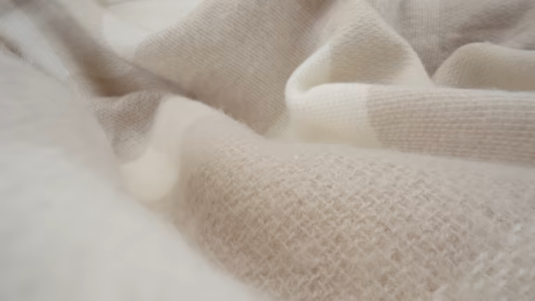 Textured natural-toned plaid woven fabric for a stylish and soft blanket.